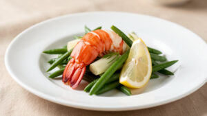 Queue de langouste pochée décortiquée, accompagnée de haricots verts fins, de fenouil braisé et d’un quartier de citron dans un dressage gastronomique lumineux.